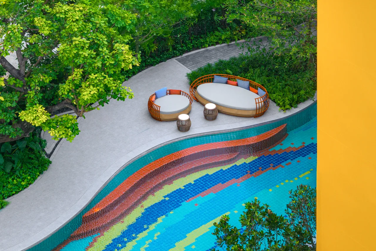 The Base Rise, Phuket: elevated view of poolside seating and colourful pool tiles